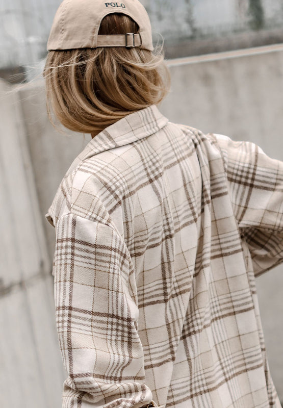 Oversized plaid shacket with attached hoodie in beige and brown plaid, shown from the back.