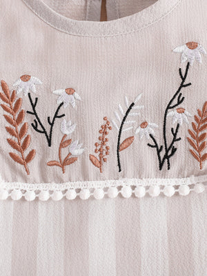 Baby two-piece set with floral embroidery and pom-pom trim.