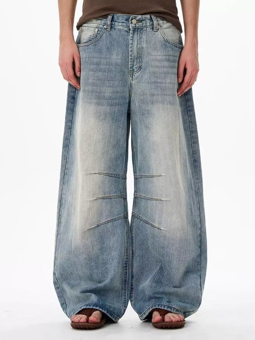 Men's light wash denim wide leg jeans with faded details and relaxed fit.