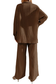 Brown pleated co-ord set with button-down shirt and wide leg trousers.