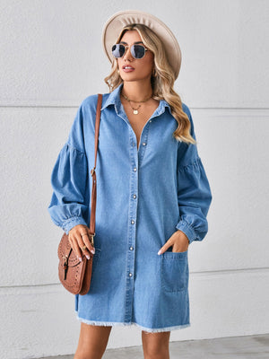 Denim shirtdress in dark blue with voluminous sleeves, button front, pockets, and frayed hem.