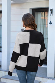 Checkerboard knit crewneck sweater in black and light grey acrylic with long sleeves.