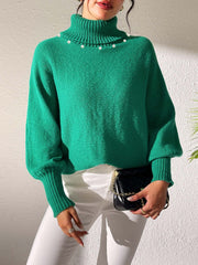 Green knit sweater with pearl-embellished turtleneck and dolman sleeves.