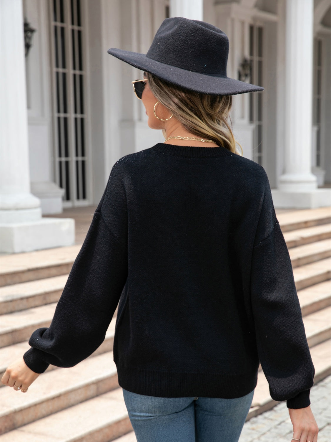 Black acrylic knit sweater with balloon sleeves and a subtle heart motif.