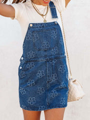 Embroidered denim pinafore dress in peacock blue with a floral pattern.