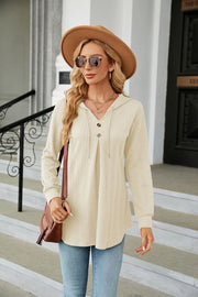 Textured ivory henley hooded tunic with button detail and drawstring.