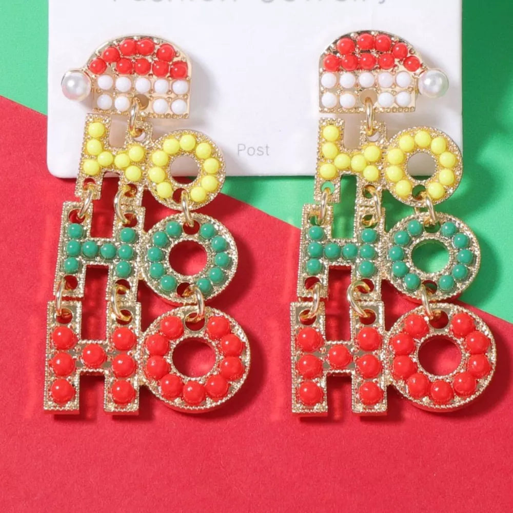 Festive holiday earrings with "HO HO HO" text, Santa hat detail, and pearl accent.