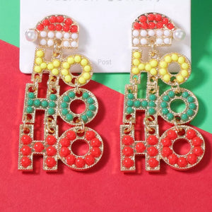 Festive holiday earrings with "HO HO HO" text, Santa hat detail, and pearl accent.