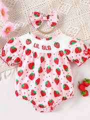 Baby pink cotton smocked one-piece with strawberry print and bow headband.