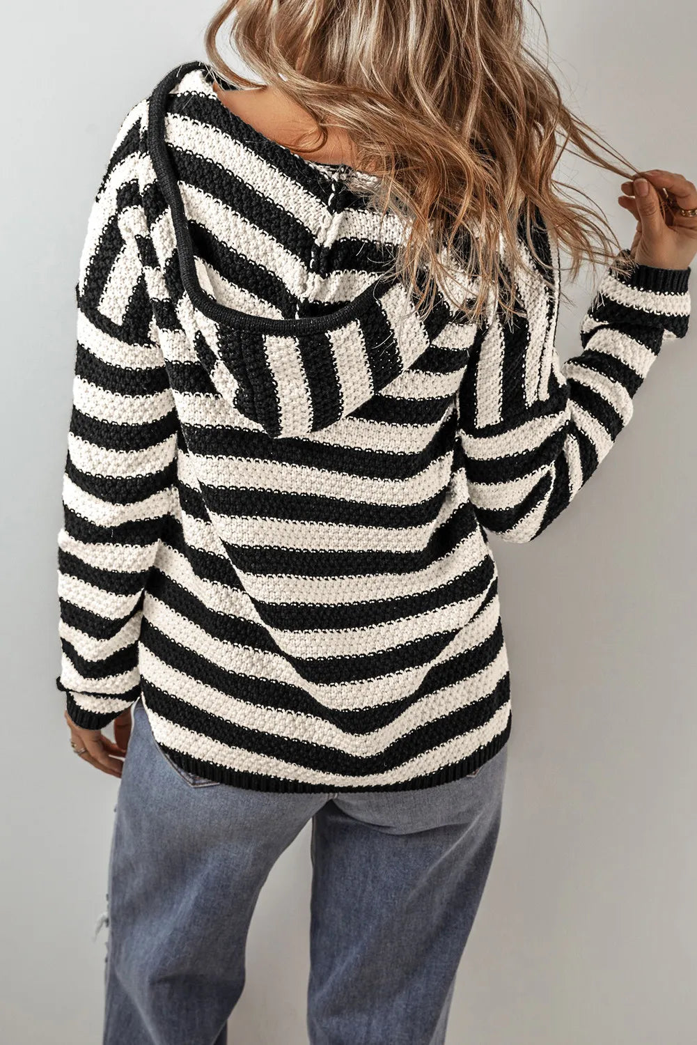 Black and white striped knit hoodie with textured pattern and pouch pocket.