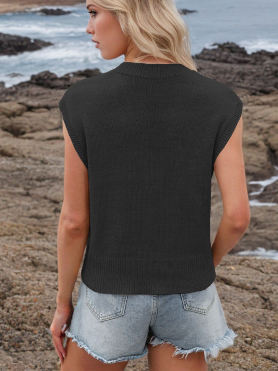 Black knit V-neck sleeveless sweater top with ribbed hem and cuffs.