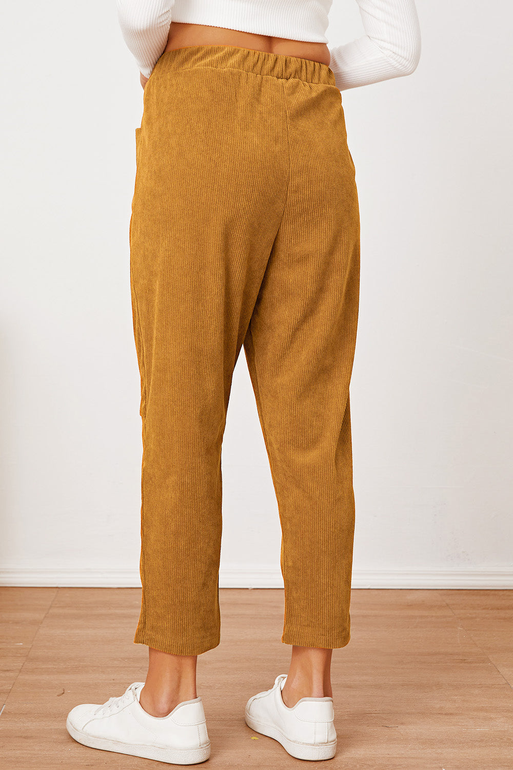Mustard corduroy barrel-leg utility pants with elastic waist and pockets.