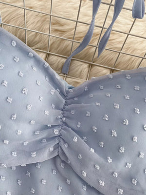 Blue Swiss dot maternity blouse with ruched detail and tie straps.