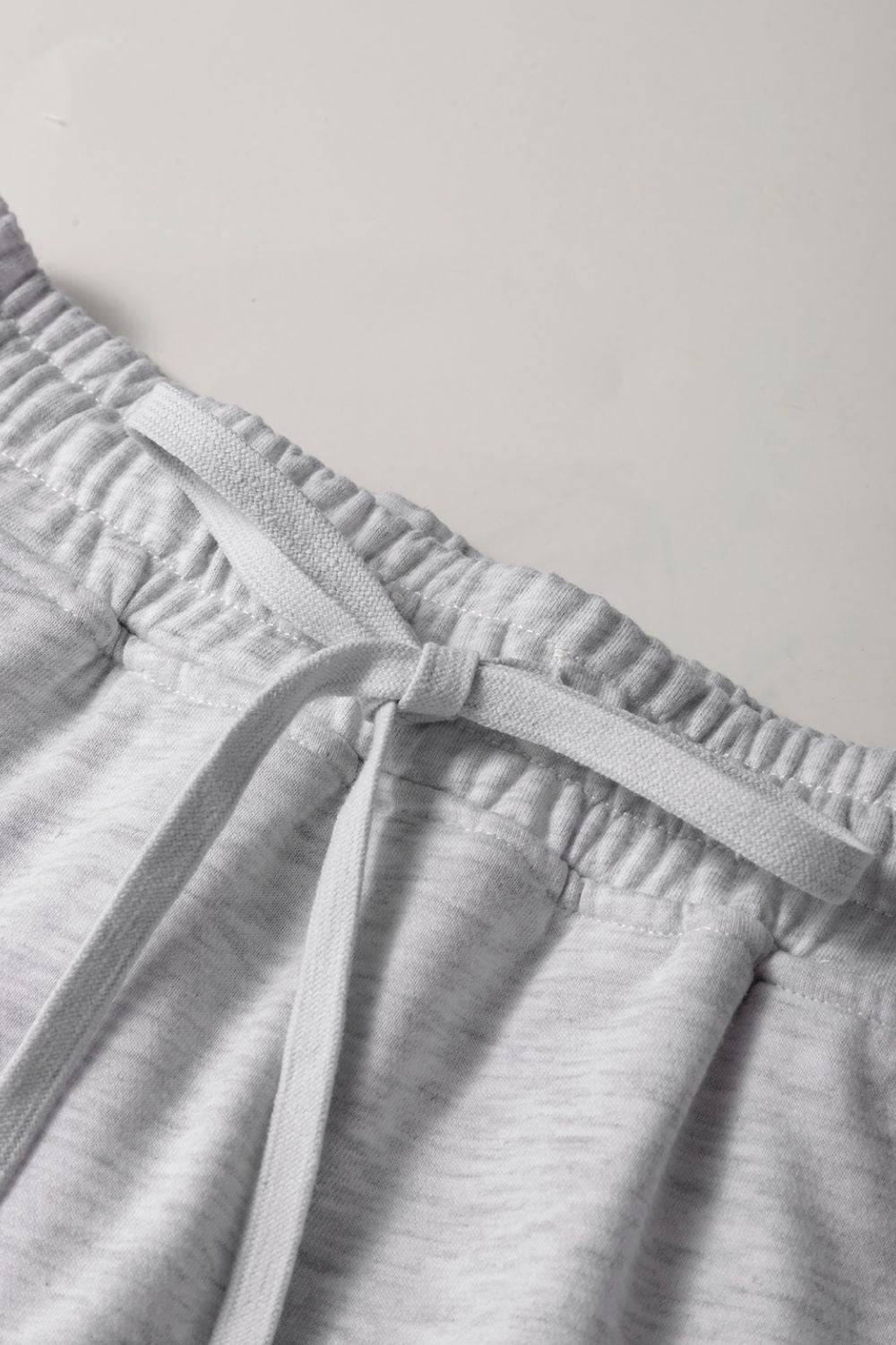 Light gray French terry skort with drawstring and elastic waistband detail.