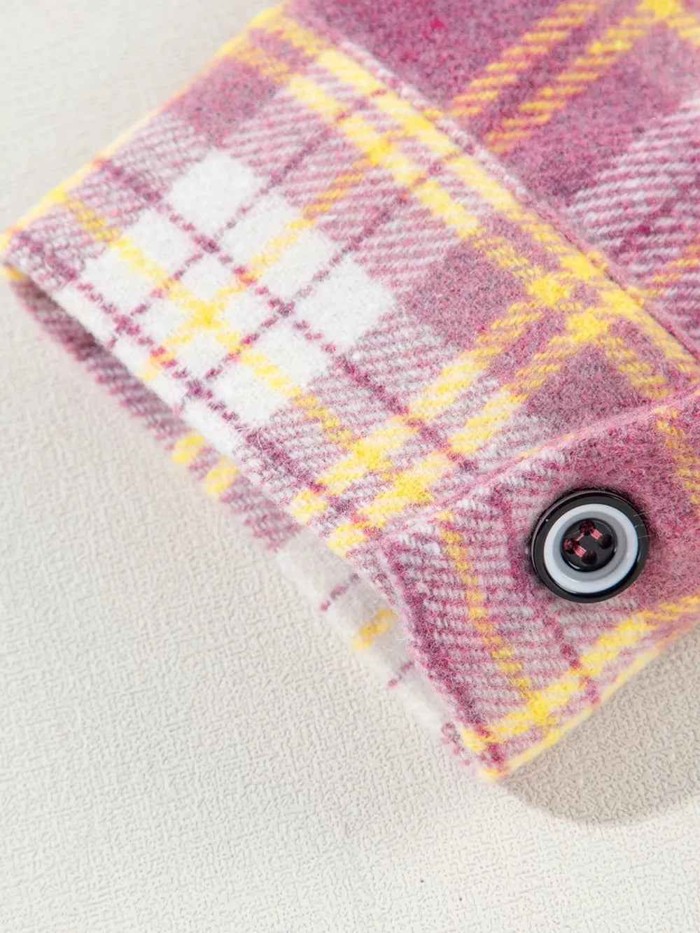 Oversized shacket with pink, yellow, and white plaid pattern and button cuff detail.