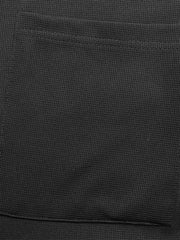 Black textured knit jumpsuit with a visible pocket detail.