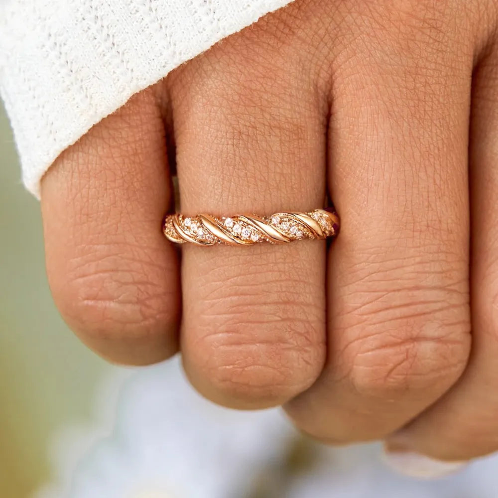 Gold twisted band ring with cubic zirconia accents on sterling silver.