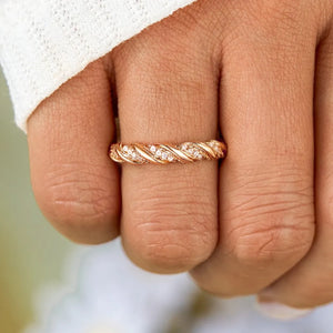 Gold twisted band ring with cubic zirconia accents on sterling silver.