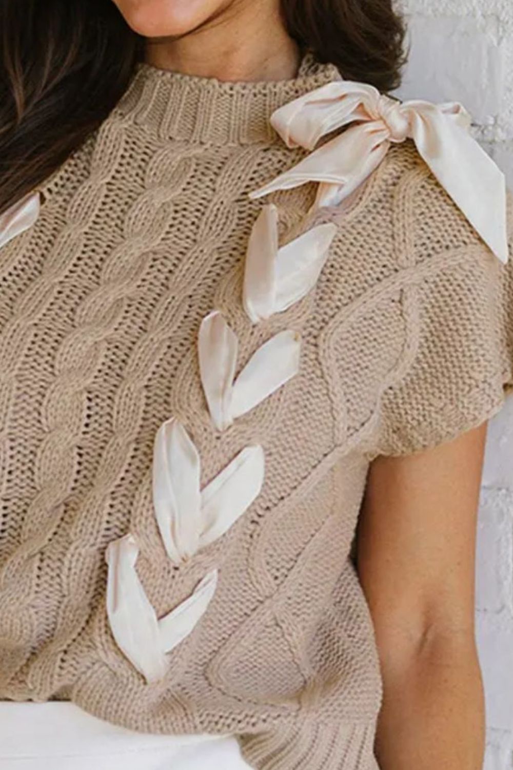 Mocha cable knit sweater with mock neck and bow details on shoulder and chest.