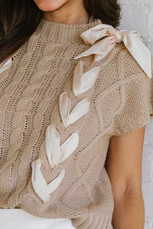 Mocha cable knit sweater with mock neck and bow details on shoulder and chest.