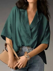 Dark green V-neck half sleeve shirt with a relaxed fit, styled with jeans and a handbag.