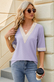 Lavender textured V-neck blouse with lace trim and short sleeves.