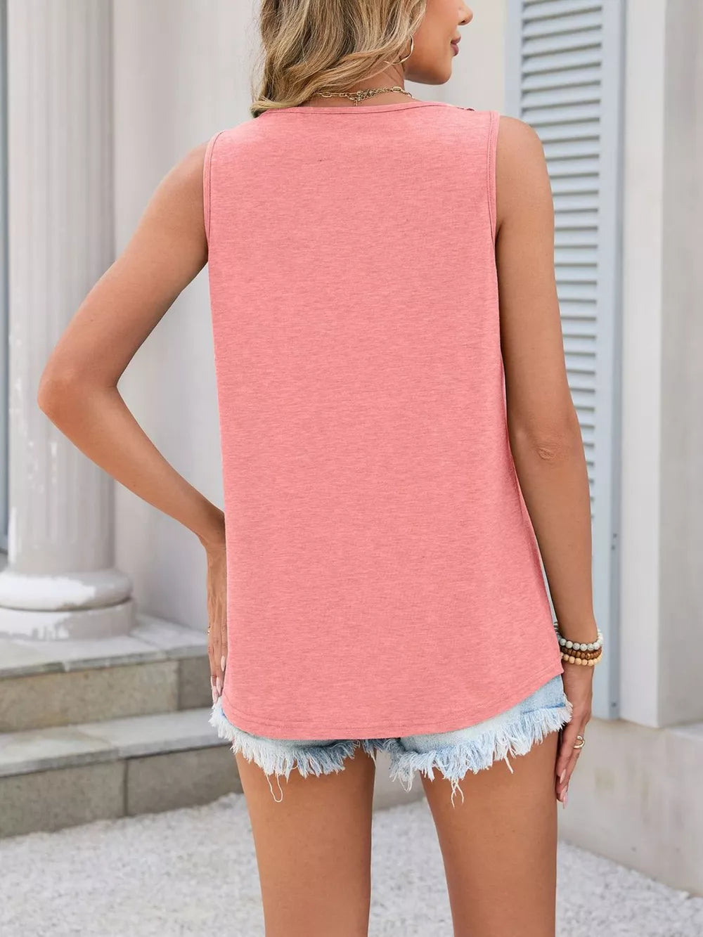 Coral sleeveless tank top with lace trim detail and a relaxed fit.