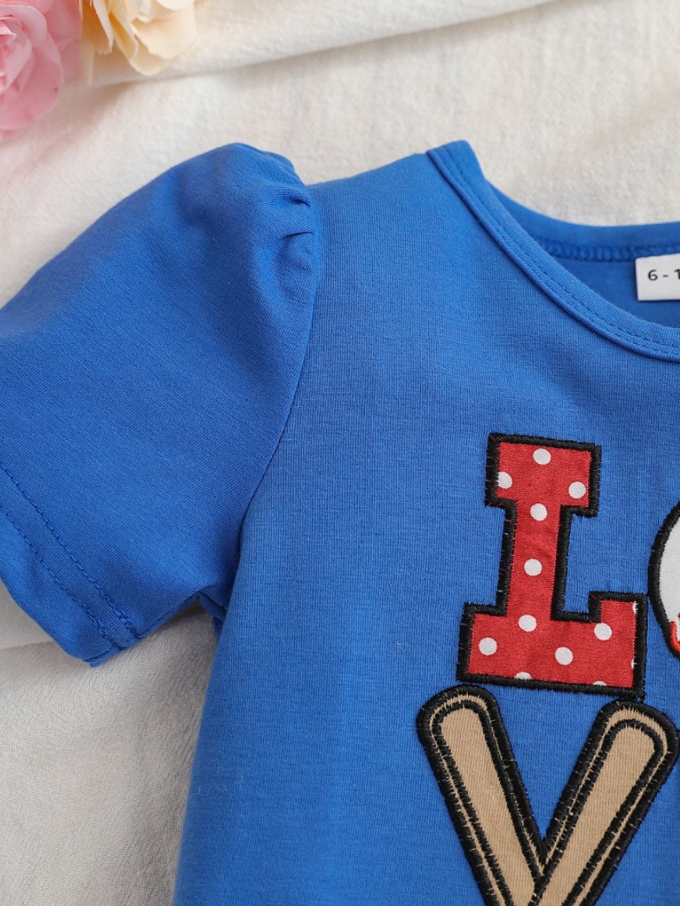 Blue cotton tee with puff sleeves and baseball "LOVE" applique detail.