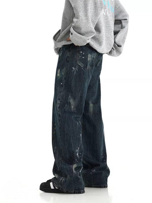 Distressed dark blue wide-leg jeans with paint splatters and a baggy fit.