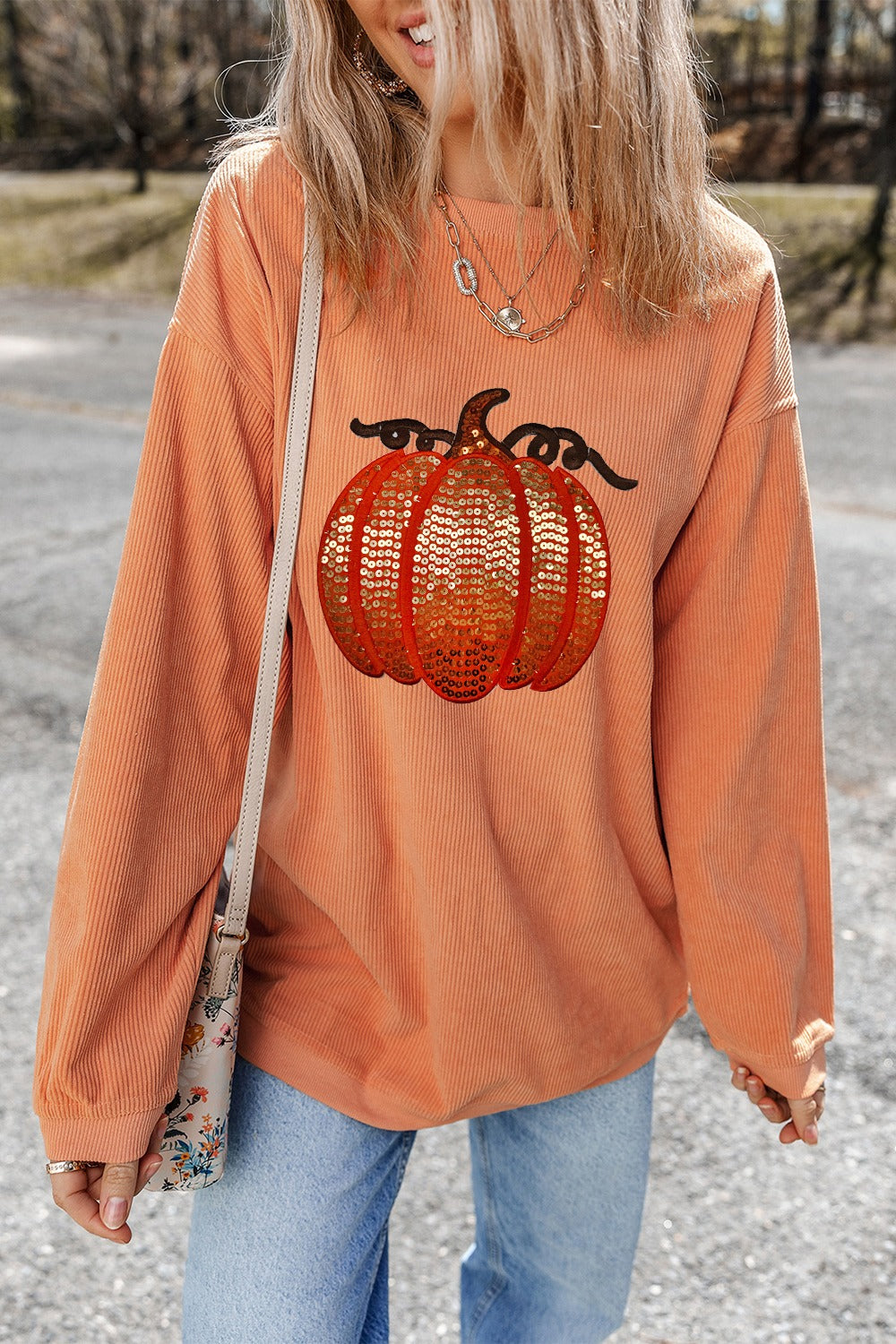 Sequin pumpkin corduroy sweatshirt in sherbet with relaxed fit and long sleeves.