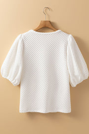 White textured quilted blouse with puff sleeves and a round neckline.