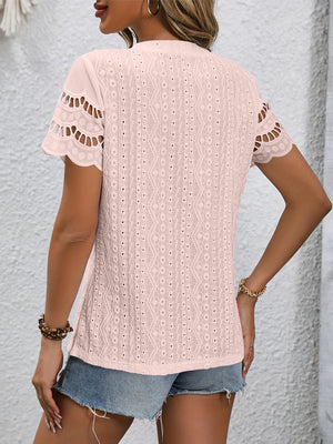 Pink scalloped eyelet sleeve blouse with allover geometric eyelet pattern.