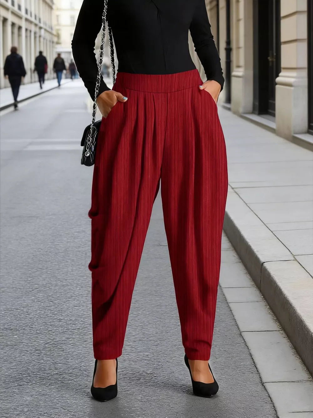 Burgundy ribbed casual maternity pants with a draped front and pockets.