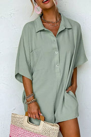 Sage green collared button-down romper with half sleeves and chest pocket.