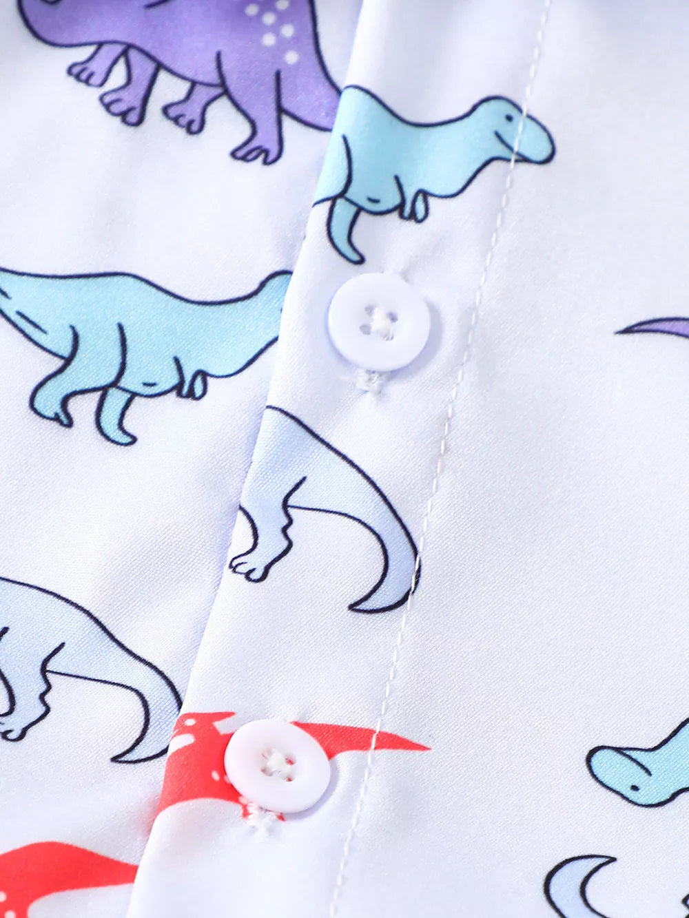 Toddler shirt with blue and purple dinosaur print, white buttons, cotton fabric.