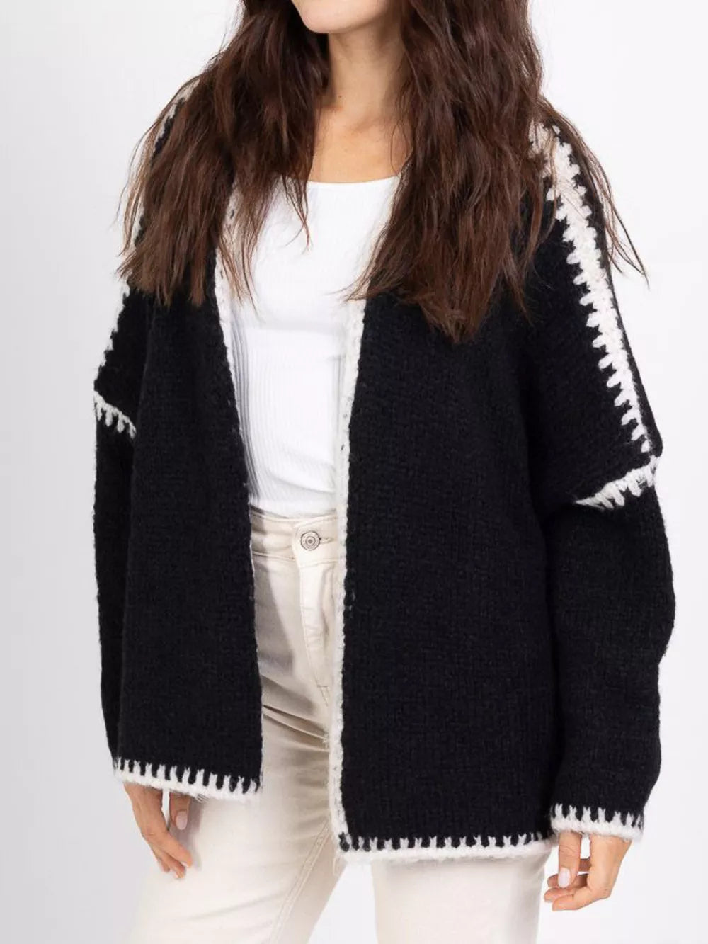 Black oversized cardigan with white contrast trim and crochet detail on sleeves and hem.