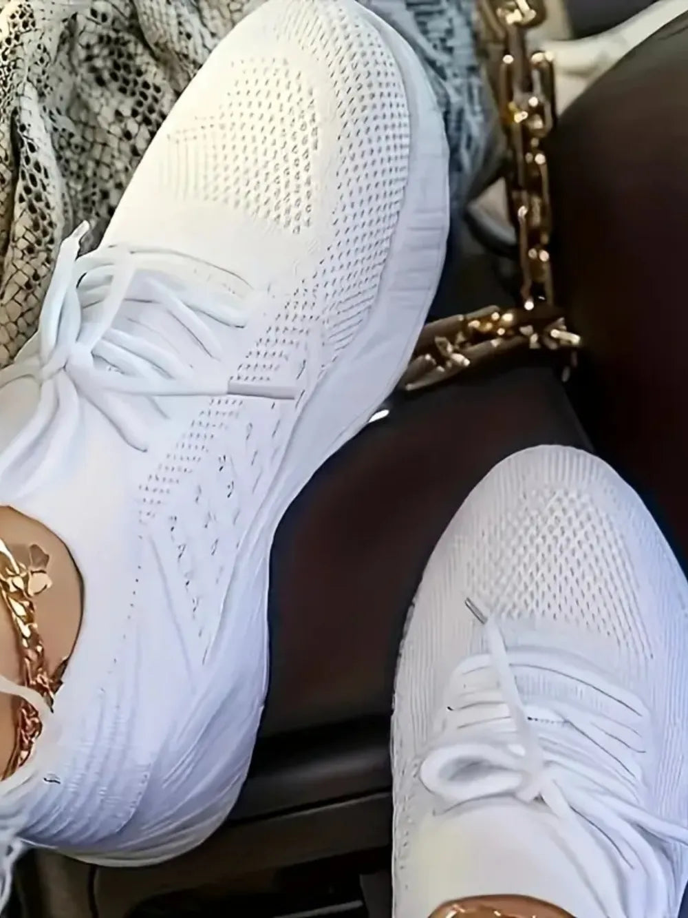 White knit runner sneakers with sculpted sole and gold chain detail.