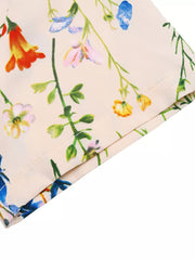 A-line maxi dress in cream with a multicolor floral print and square neckline detail.