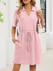 Pink textured polo dress with short sleeves, V-neck, and adjustable drawstring waist.