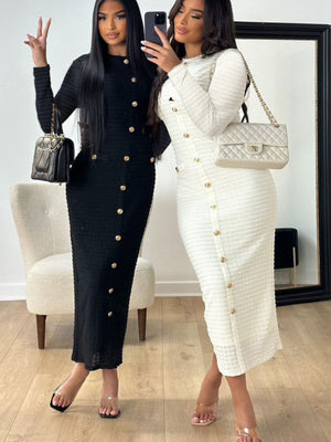 Chic textured midi dress in black and white with decorative gold buttons and crew neck.