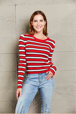 Ribbed knit crewneck sweater with red, white, and black stripes and long sleeves.