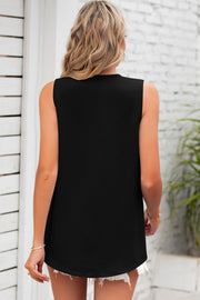 Black textured sleeveless blouse with a curved hem, styled with white shorts.