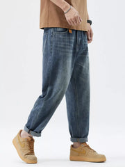 Men's blue washed stretch denim jeans with a relaxed fit and cuffed hems.