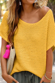 Open-knit dolman sleeve top in gold with a boat neck, styled casually.