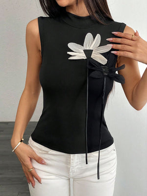 Black ribbed mock neck sleeveless top with floral appliqué detail and ties.