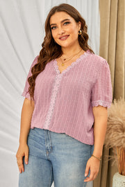 Dusty pink textured dot blouse with lace trim V-neck and short sleeves.