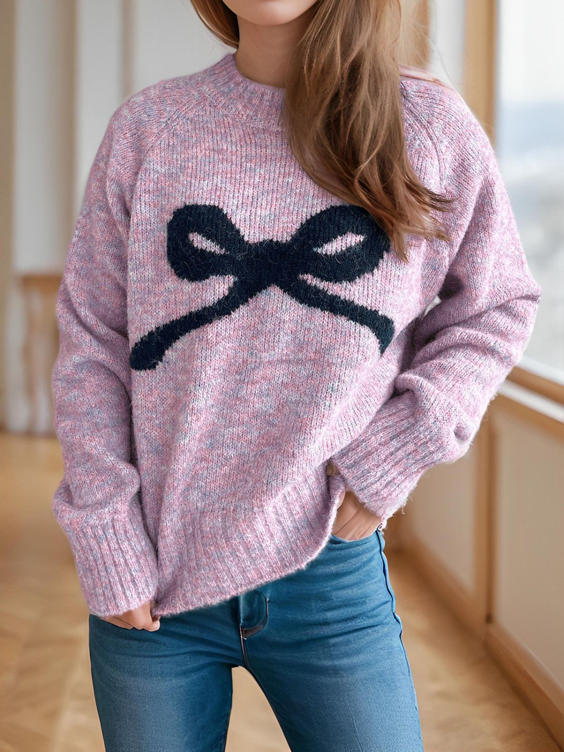 Pink purple knit sweater with black bow intarsia design and crew neck.
