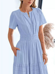 Light blue tiered midi dress with V-neck, short sleeves, smocked waist, and pockets.