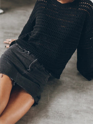 Black open-knit sweater with bell sleeves and a relaxed fit.