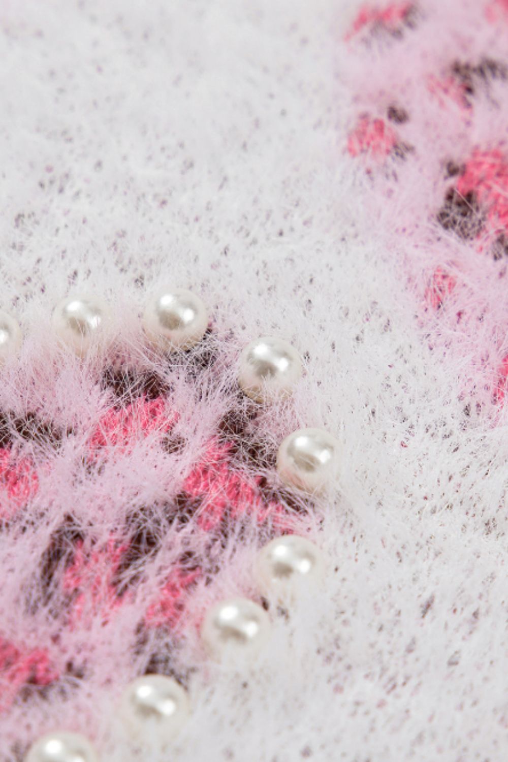 Fuzzy knit sweater in blush pink with jacquard heart pattern and pearl embellishments.